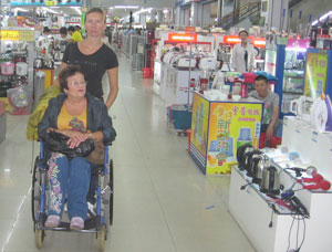 Фото. Хуньчунь (КНР). Православные добровольцы сопровождают инвалидов-спинальников в их поездке по Китаю: помогают передвигаться по торговому центру