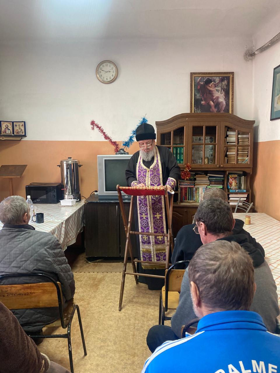 Священник служит молебны в приюте для бездомных.